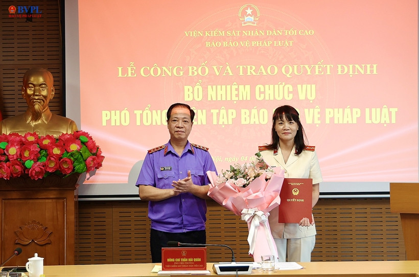 Đồng chí Trần Hải Quân, Phó Viện trưởng VKSND tối cao trao quyết định và tặng hoa chúc mừng đồng chí Hồ Thị Kim Thoan được bổ nhiệm giữ chức vụ Phó Tổng Biên tập Báo BVPL.