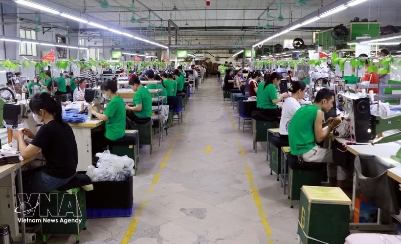 Workers at a factory producing garments for export. (Photo: VNA)