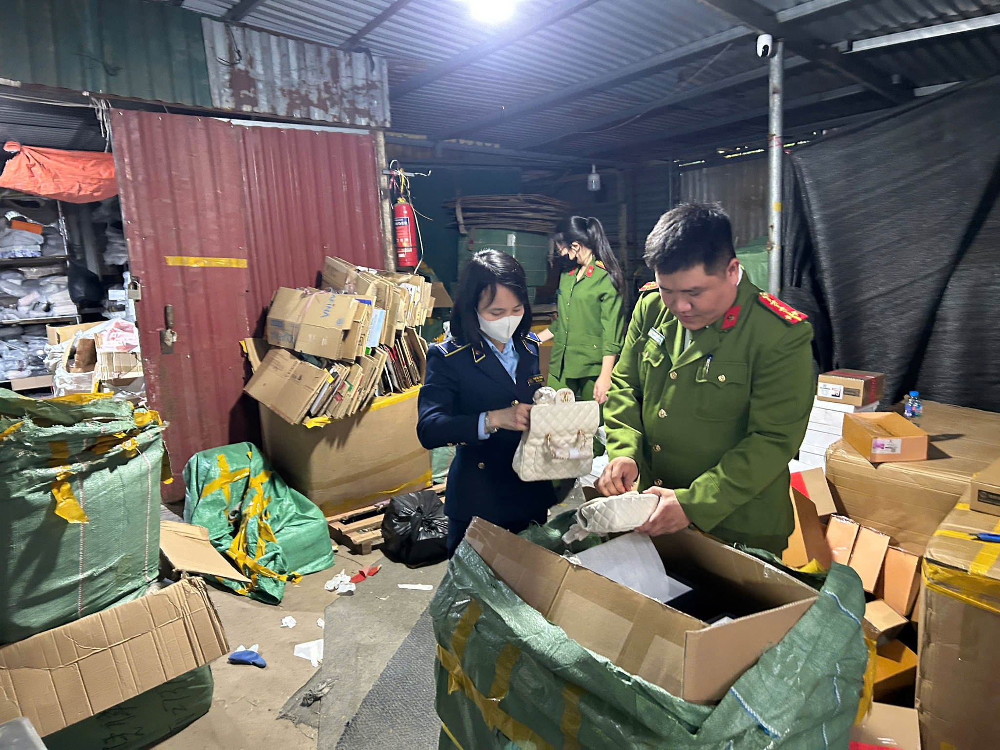 Lực lượng chức năng tiến hành kiểm tra nhiều sản phẩm có dấu hiệu giả mạo các nhãn hiệu đang được bảo hộ tại Việt Nam. Ảnh QLTT
