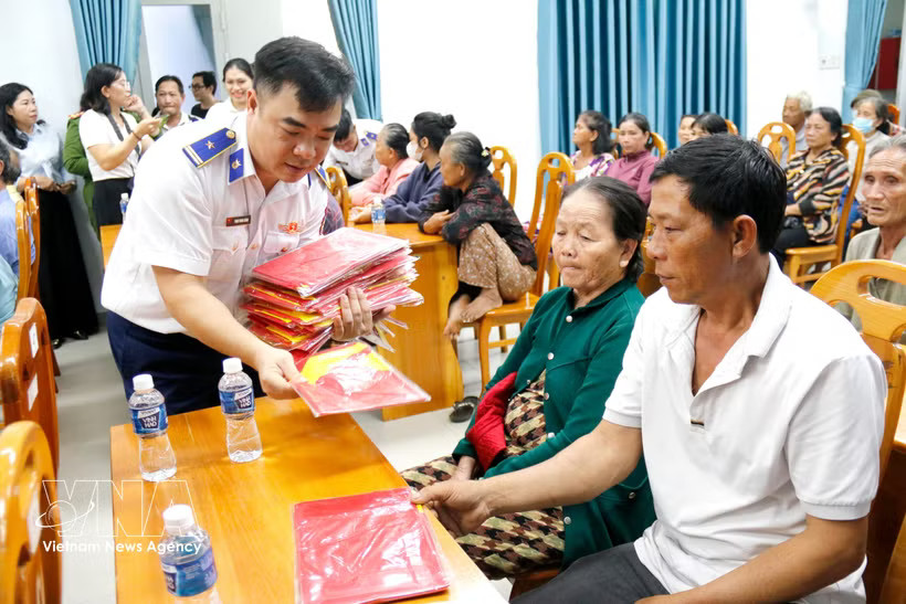 The Vietnam Coast Guard Region 3 Command presents national flags to fishermen in Tien Thanh ward, Lam Dong province (Photo: VNA)
