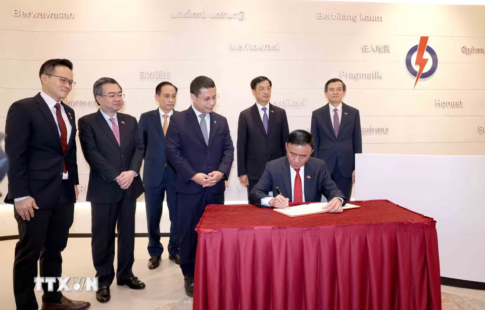 Thường trực Ban Bí thư Trần Cẩm Tú viết sổ lưu niệm tại trụ sở Đảng Hành động Nhân dân Singapore. (Ảnh: Phương Hoa/TTXVN)