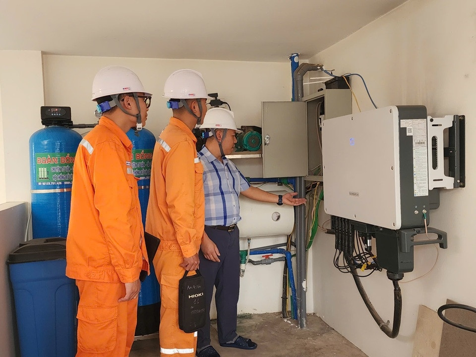 Nhân viên Điện lực hướng dẫn, hỗ trợ khách hàng kiểm tra hệ thống điện mặt trời mái nhà. Ảnh NPC