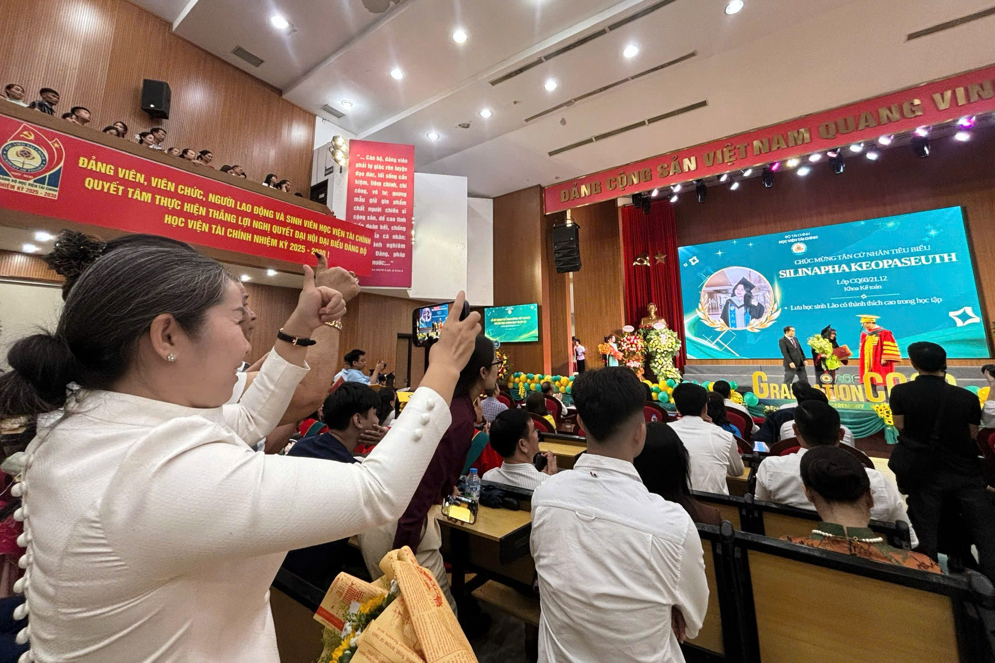 Chị Sengsouli Keopaseuth (49 tuổi, công tác tại Bộ Quốc phòng Lào) - mẹ của nữ sinh Silinapha Keopaseuth rạng rỡ theo dõi con tại buổi lễ tốt nghiệp