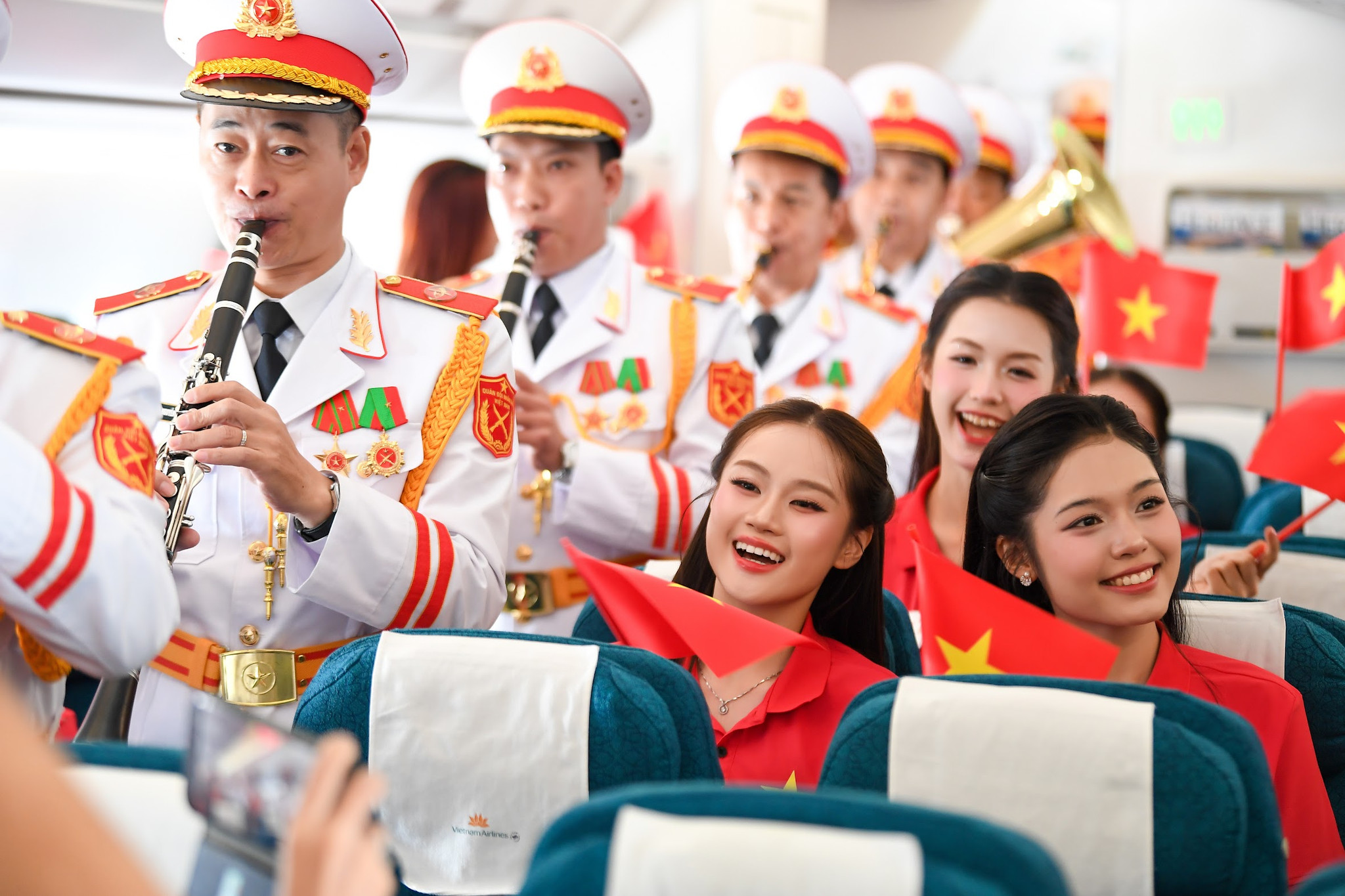 Ít phút sau, cán bộ, chiến sĩ Đoàn Nghi lễ Quân đội bắt đầu biểu diễn bằng nhạc cụ ngay trên khoang máy bay. Ba giai điệu “Đất nước trọn niềm vui”, “Nối vòng tay lớn” và “Như có Bác trong ngày đại thắng” lần lượt vang lên trên hành trình từ Hà Nội đến TP.Hồ Chí Minh. Ảnh VNA