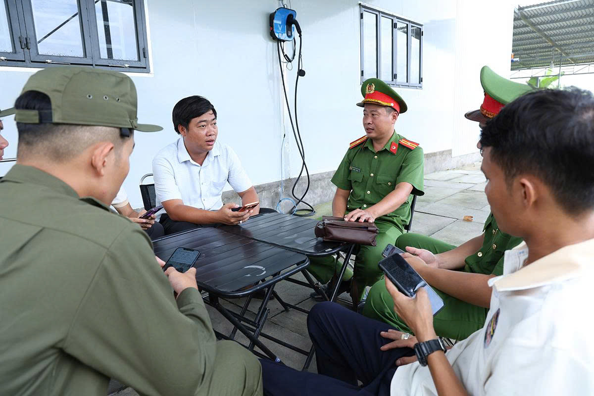 Công an xã Vĩnh Trạch tuyên truyền, hướng dẫn người dân tham gia trang fanpage “Công an xã Vĩnh Trạch”. Ảnh: Tiến Tầm