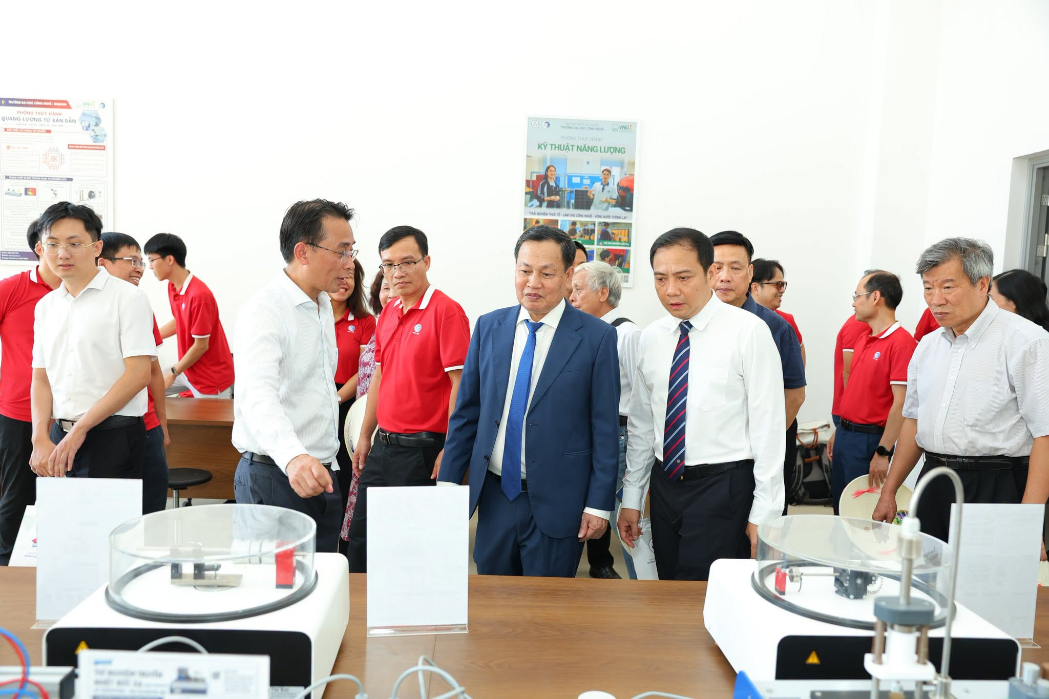 GS.TS Chử Đức Trình (áo trắng, bên trái ảnh) - Hiệu trưởng Trường ĐH Công nghệ giới thiệu các phòng thực hành, thí nghiệm với Phó Giám đốc ĐHQGHN Đào Thanh Trường (thứ hai, từ phải sang) cùng các nguyên lãnh đạ (1)