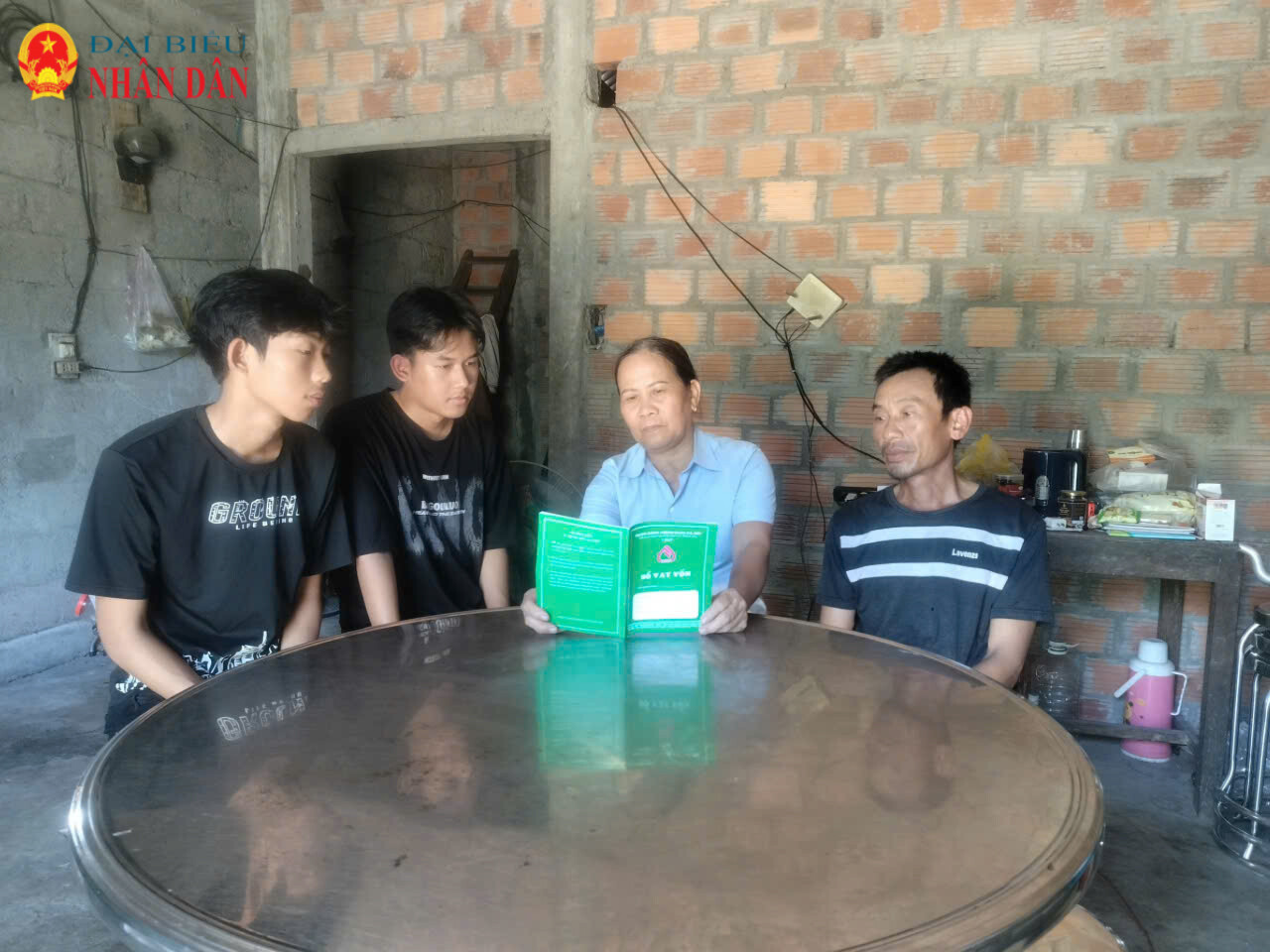 Tổ tiết kiệm và vay vốn thôn Vĩnh Lợi hướng dẫn gia đình ông Võ Đình Đài kiểm tra sổ vay vốn ưu đãi từ Ngân hàng Chính sách Xã hội.