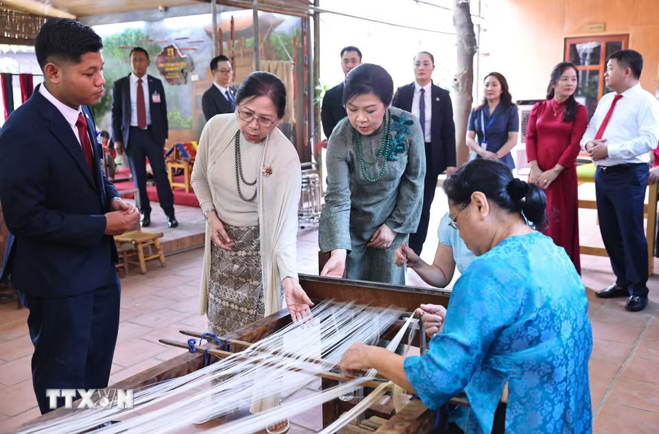 Phu nhân Ngô Phương Ly và Phu nhân Kyu Kyu Hla quan sát khung dệt và xem các nghệ nhân trình diễn nghề dệt lụa