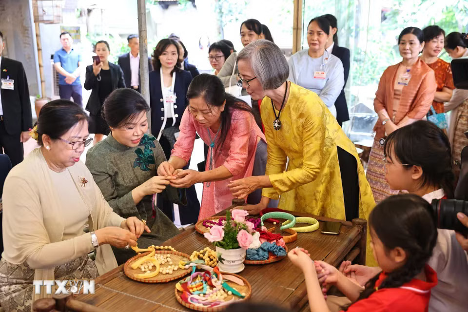 Phu nhân Ngô Phương Ly và Phu nhân Kyu Kyu Hla trải nghiệm xâu vòng lụa với các cháu thiếu niên, nhi đồng của làng nghề