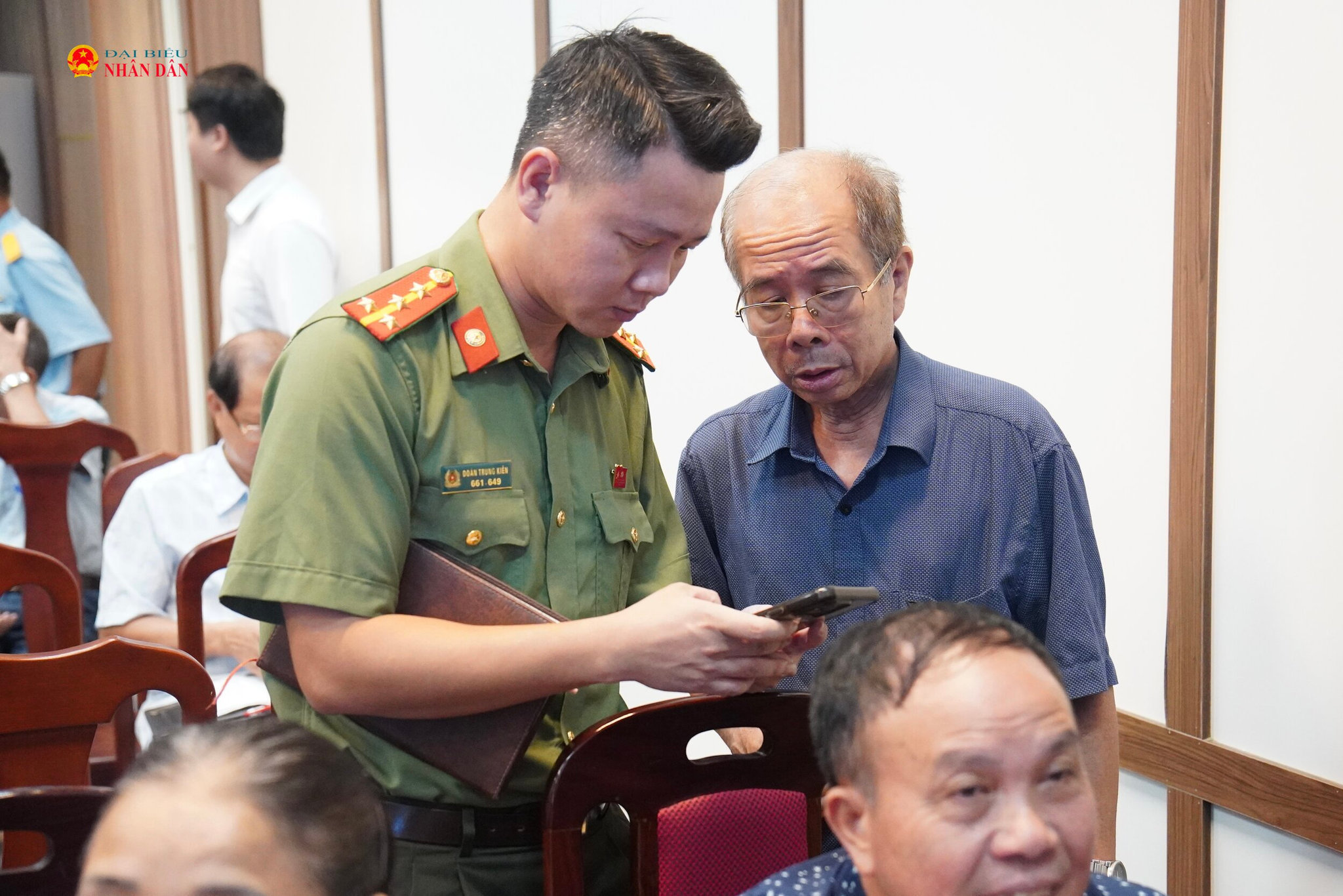 Các cán bộ chiến sĩ hỗ trợ người dân cài đặt và sử dụng ứng dụng iHanoi.