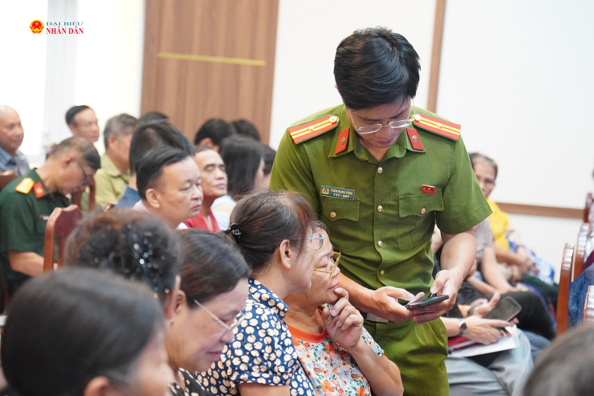Các cán bộ chiến sĩ hỗ trợ người dân cài đặt và sử dụng ứng dụng iHanoi.