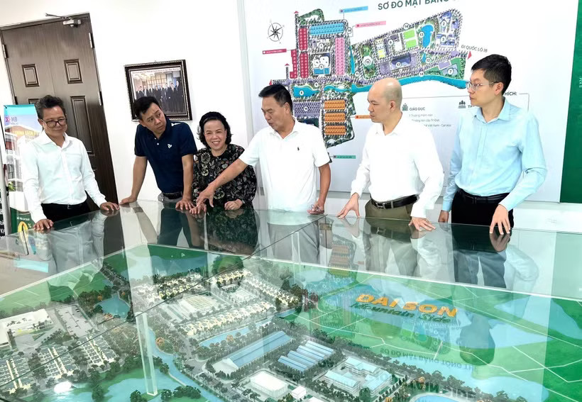 Businessman Nguyen Hoai Bac (third from right) introduces visitors to the model of Dai Son urban area, of which he is the investor. (Photo published by VNA)