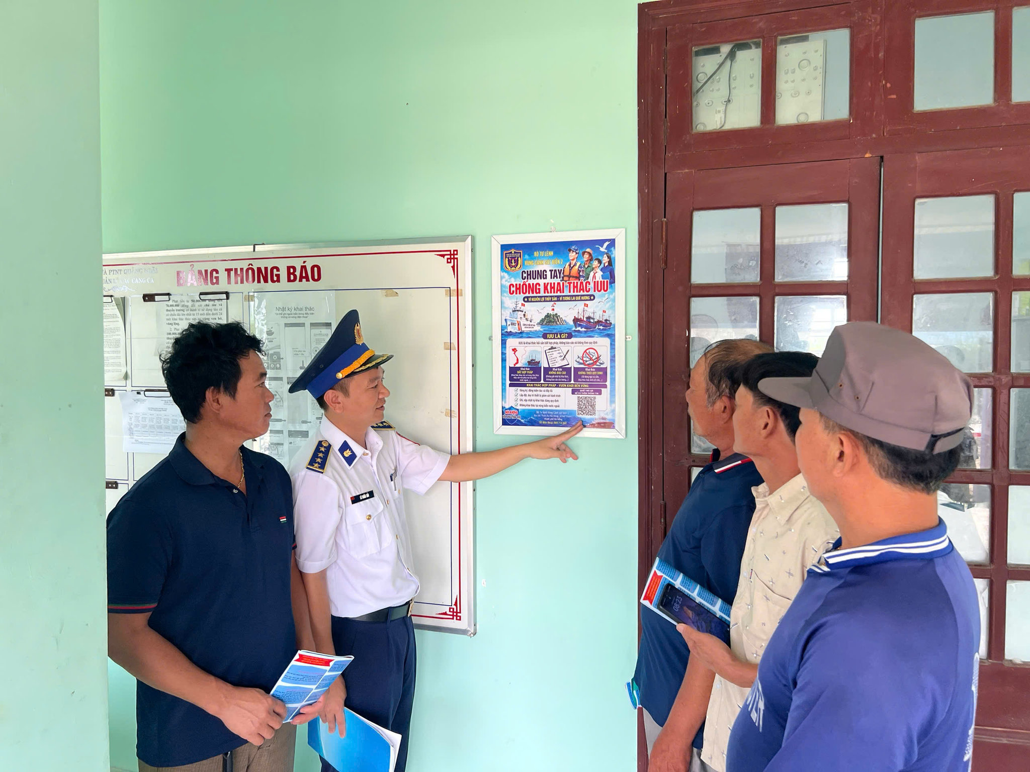 Cán bộ Bộ Tư lệnh Vùng Cảnh sát biển 2 hướng dẫn ngư dân quét mã QR về chống khai thác IUU. Ảnh: Khắc Hải