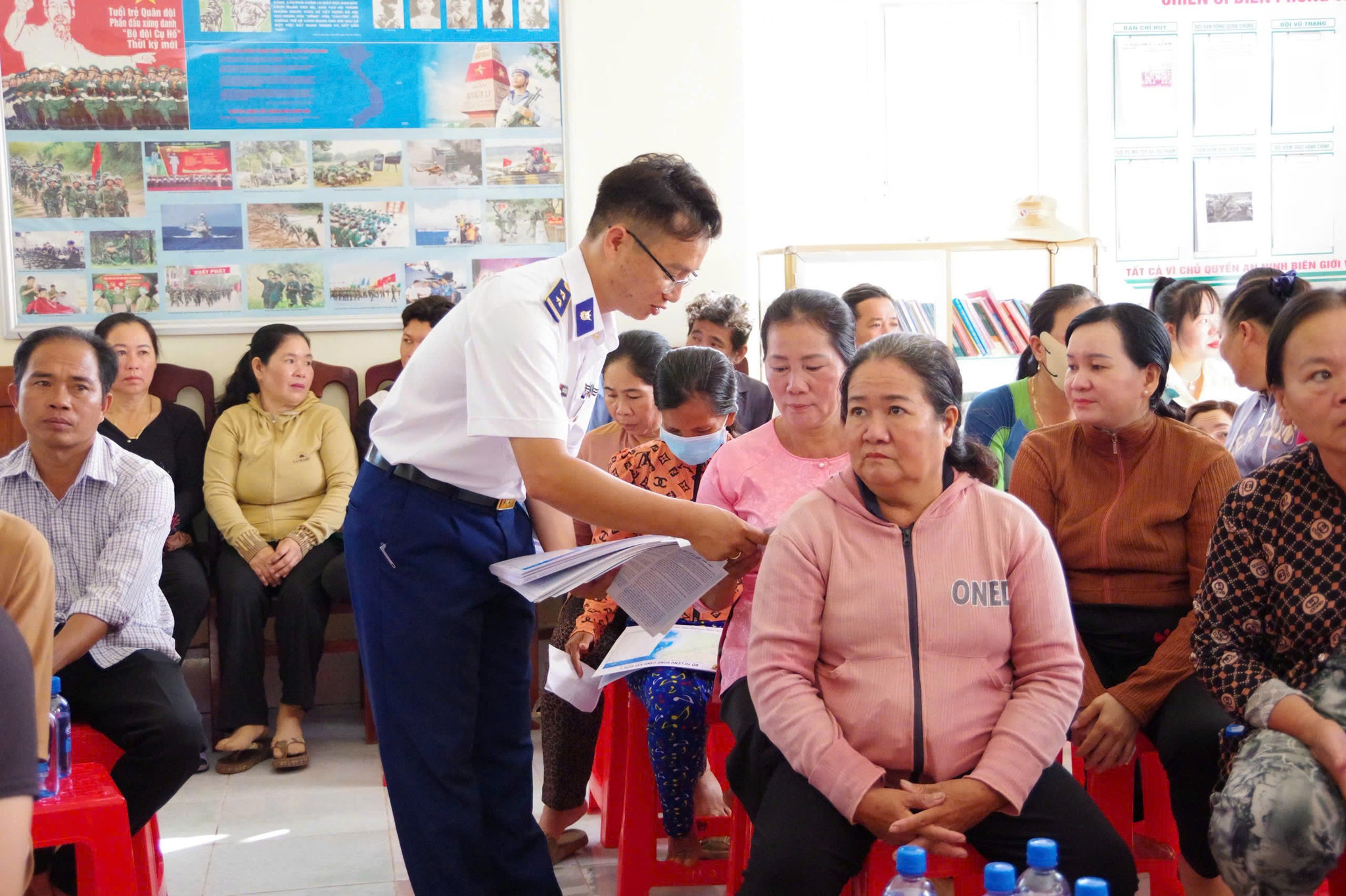 Cán bộ Bộ Tư lệnh Vùng Cảnh sát biển 4 phát tờ rơi tuyên truyền, sổ tay pháp luật cho bà con ngư dân.