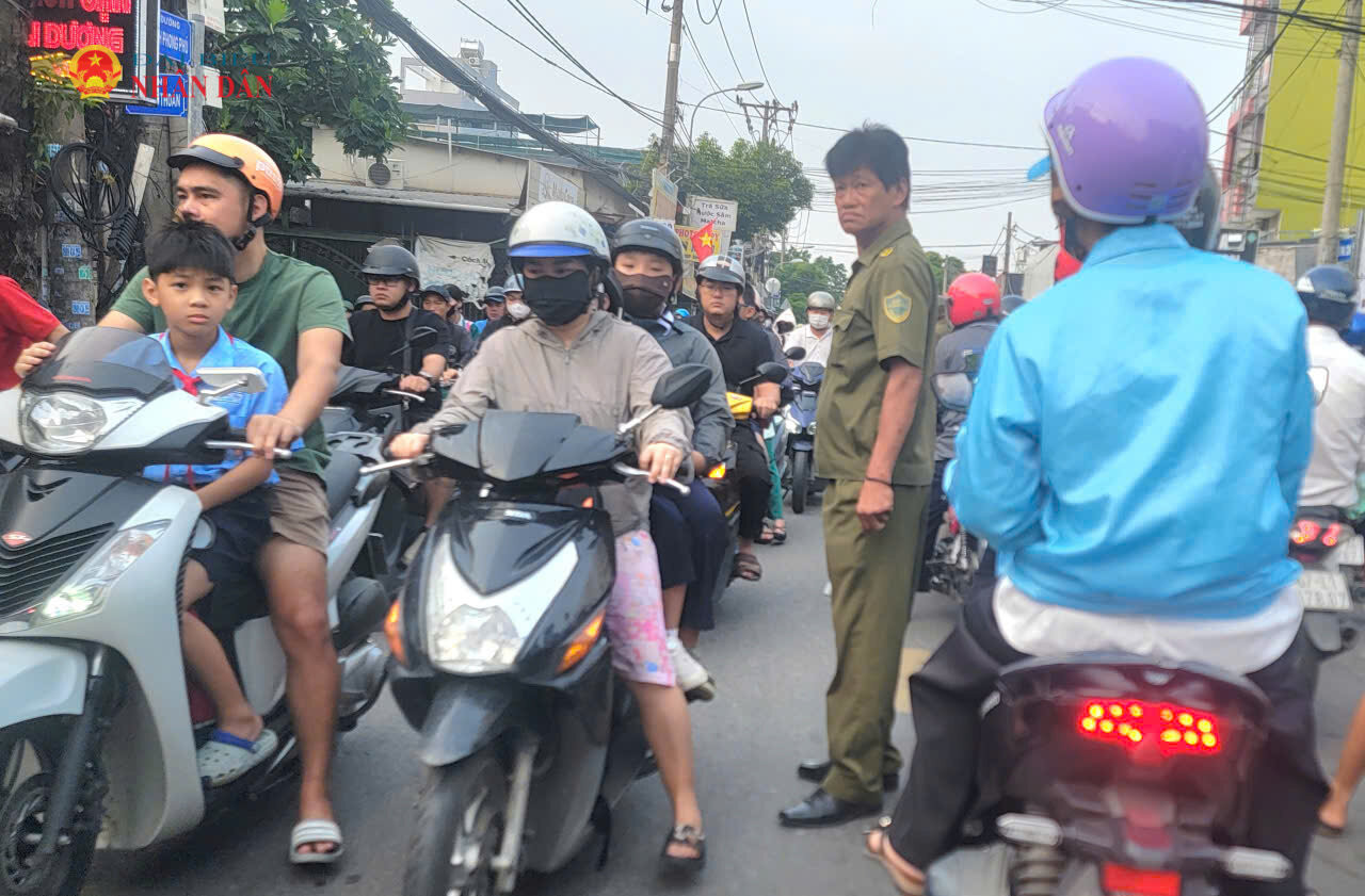 Một thành viên Tổ BVANTT của phường Tăng Nhơn Phú tham gia điều tiết giao thông tại ngã ba đường Đình Phong Phú và Bưng Ông Thoàn sáng 16/9