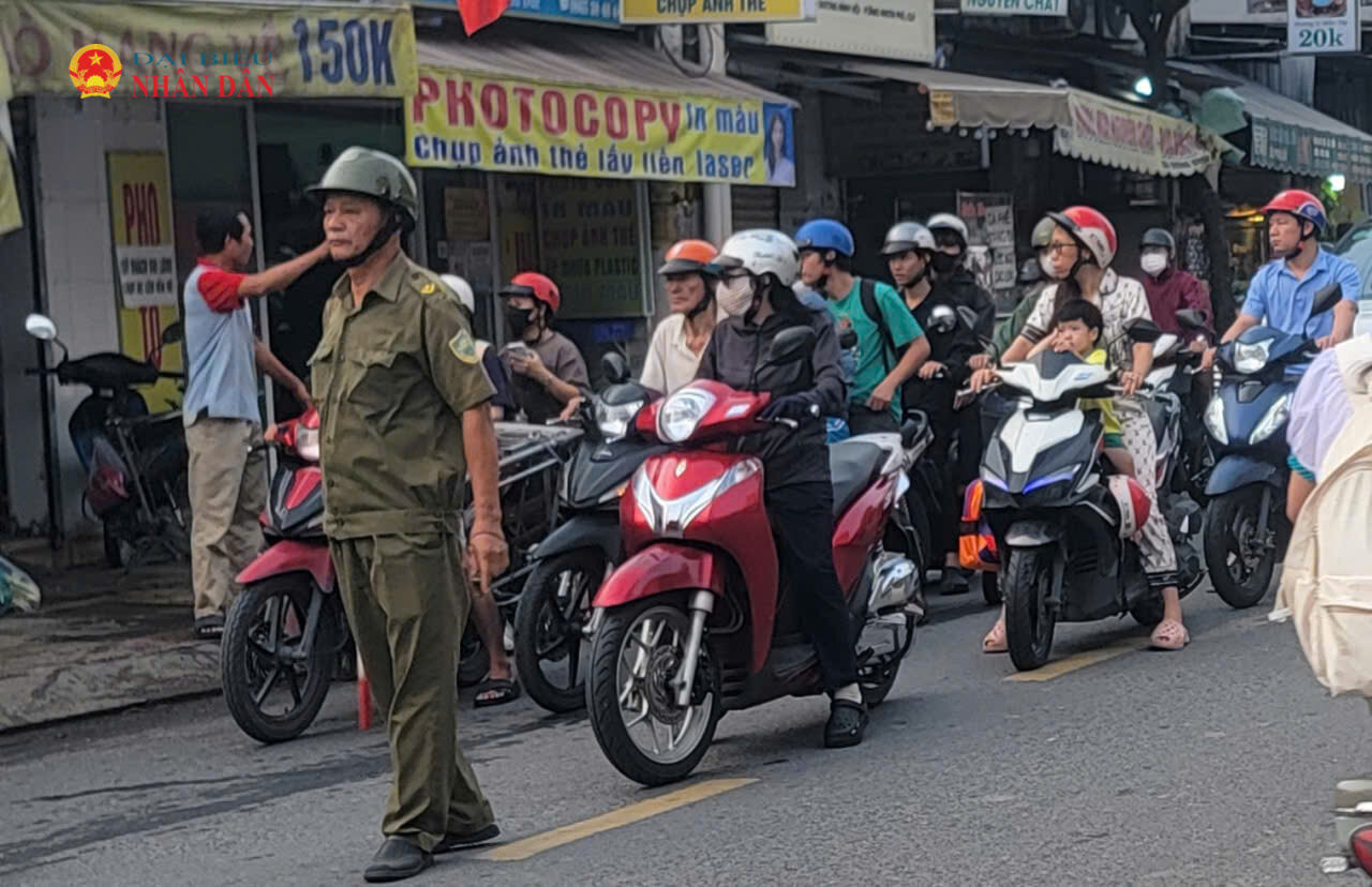 Một thành viên Tổ Bảo vệ an ninh trật tự tại phường Tăng Nhơn Phú tham gia điều tiết giao thông trên đường Đình Phong Phú sáng 16/9