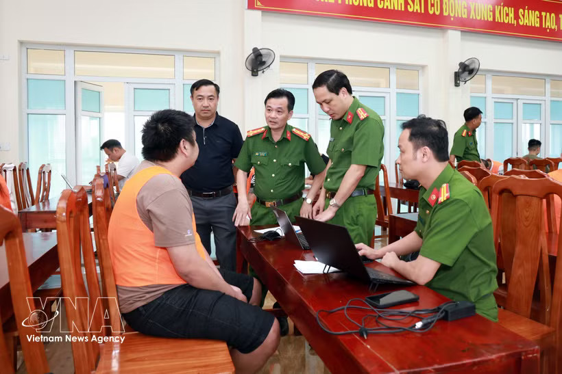 A suspect from the transnational online fraud ring is investigated (Photo: VNA)