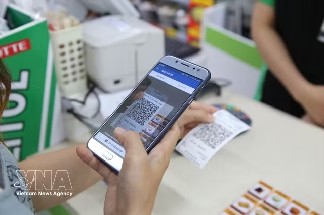 A customer conducts a QR payment. In the first eight months of the year, QR payments alone reached 10.6 billion USD. (Photo: VNA)