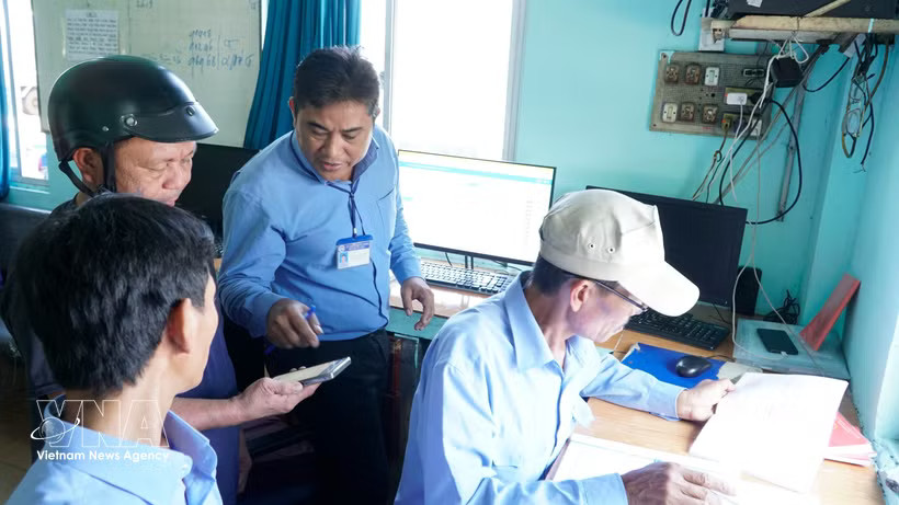 Staff at Quy Nhon Fishing Port instruct fishermen in using electronic fishing logs. (Photo: VNA)