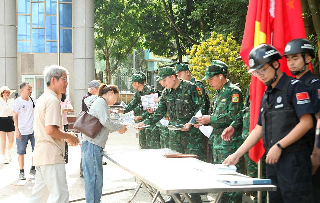 Các lực lượng phát tờ rơi tuyên truyền pháp luật cho cư dân qua lại cửa khẩu
