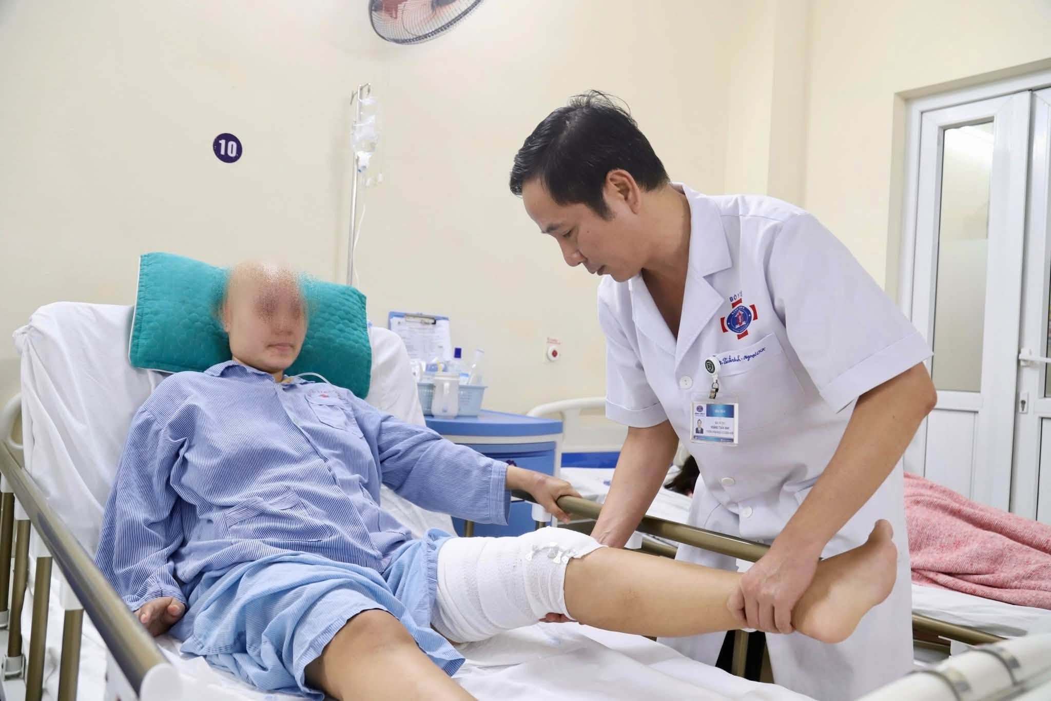 Bác sĩ kiểm tra khả năng vận động chân trái của bệnh nhân sau phẫu thuật