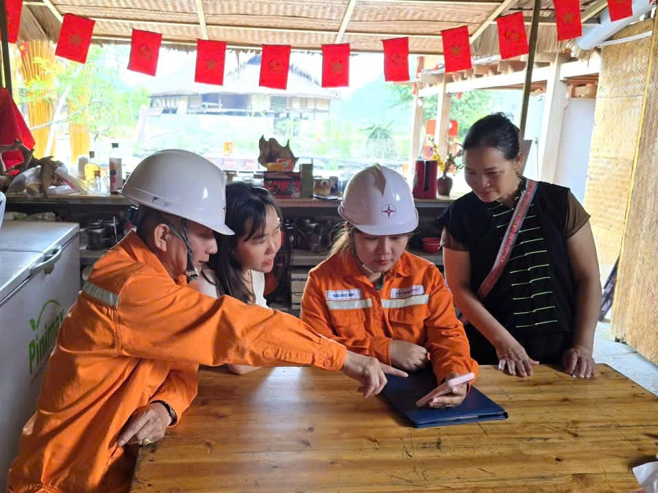 Cán bộ nhân viên Điện lực Hà Giang hướng dẫn người dân cách xem tiền điện trên ứng dụng Chăm sóc khách hàng của ngành Điện