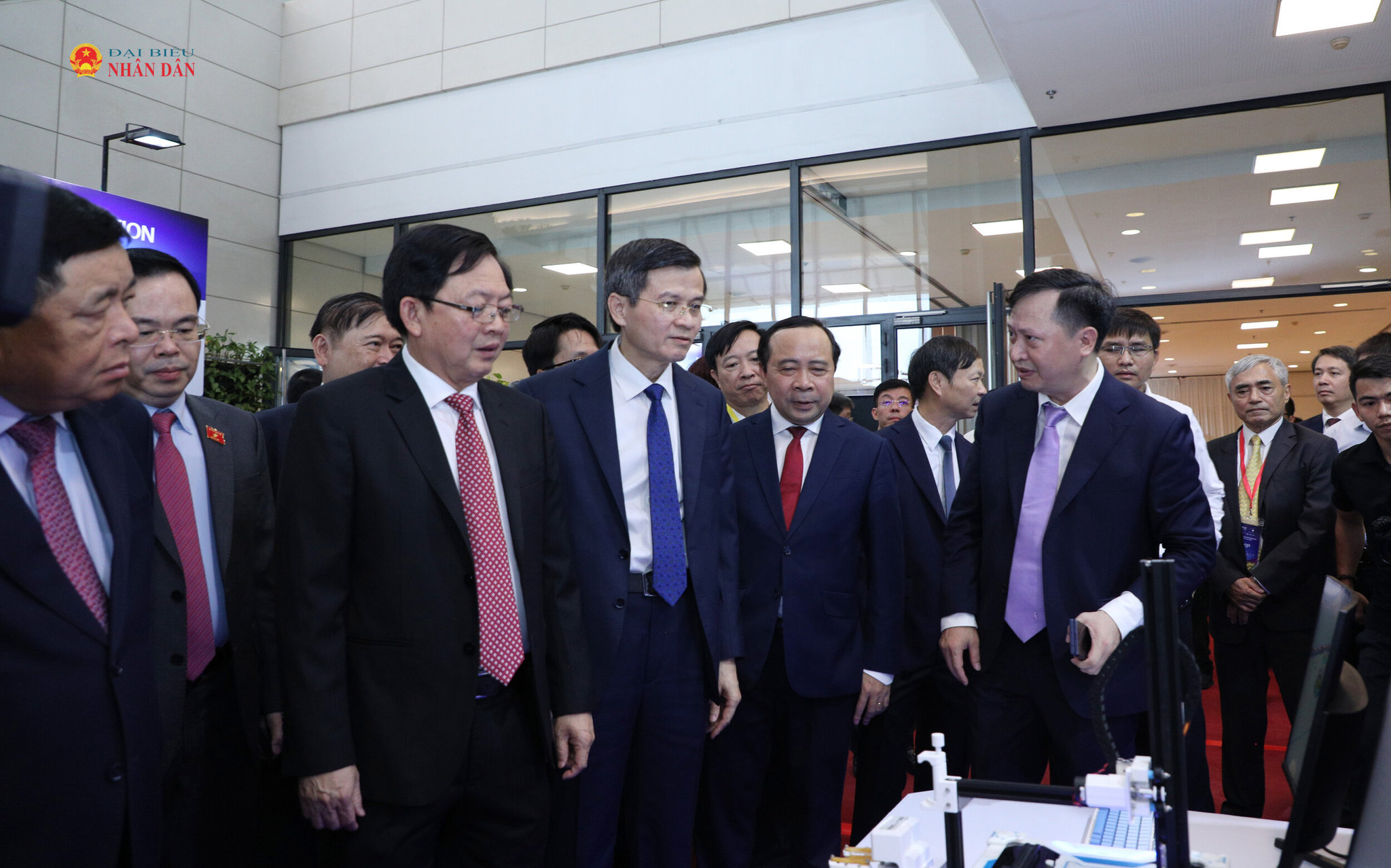 Ủy viên Bộ Chính trị, Giám đốc Học viện Chính trị quốc gia Hồ Chí Minh Đoàn Minh Huấn cùng Phó thủ tướng Chính phủ Hồ Quốc Dũng; Bộ trưởng Bộ Khoa học và Công nghệ Vũ Hải Quân tham quan sản phẩm KH và CN