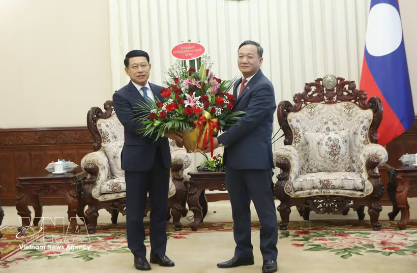 Vietnamese Ambassador to Laos Nguyen Minh Tam (R) hands over flowers from Prime Minister Le Minh Hung to congratulate Lao PM Saleumxay Kommasith. (Photo: VNA)