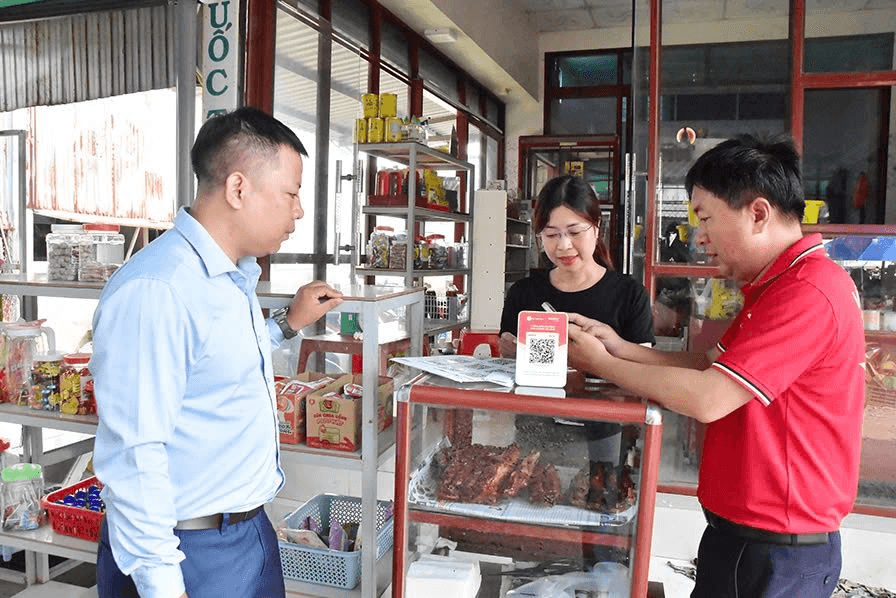 Nhân viên Viettel hỗ trợ tiểu thương chợ Nhị Long dùng phương thức thanh toán không dùng tiền mặt