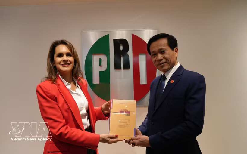 Assoc. Prof. Dr. Hoang Phuc Lam (right), Deputy Secretary of the Party Committee and Vice President of the Ho Chi Minh National Academy of Politics, presents the book “The Aspiration for a Strong and Prosperous Vietnam in the New Era” to Sofia Carvajal, head of the Institutional Revolutionary Party (PRI) Committee for Foreign Affairs. (Photo: VNA)