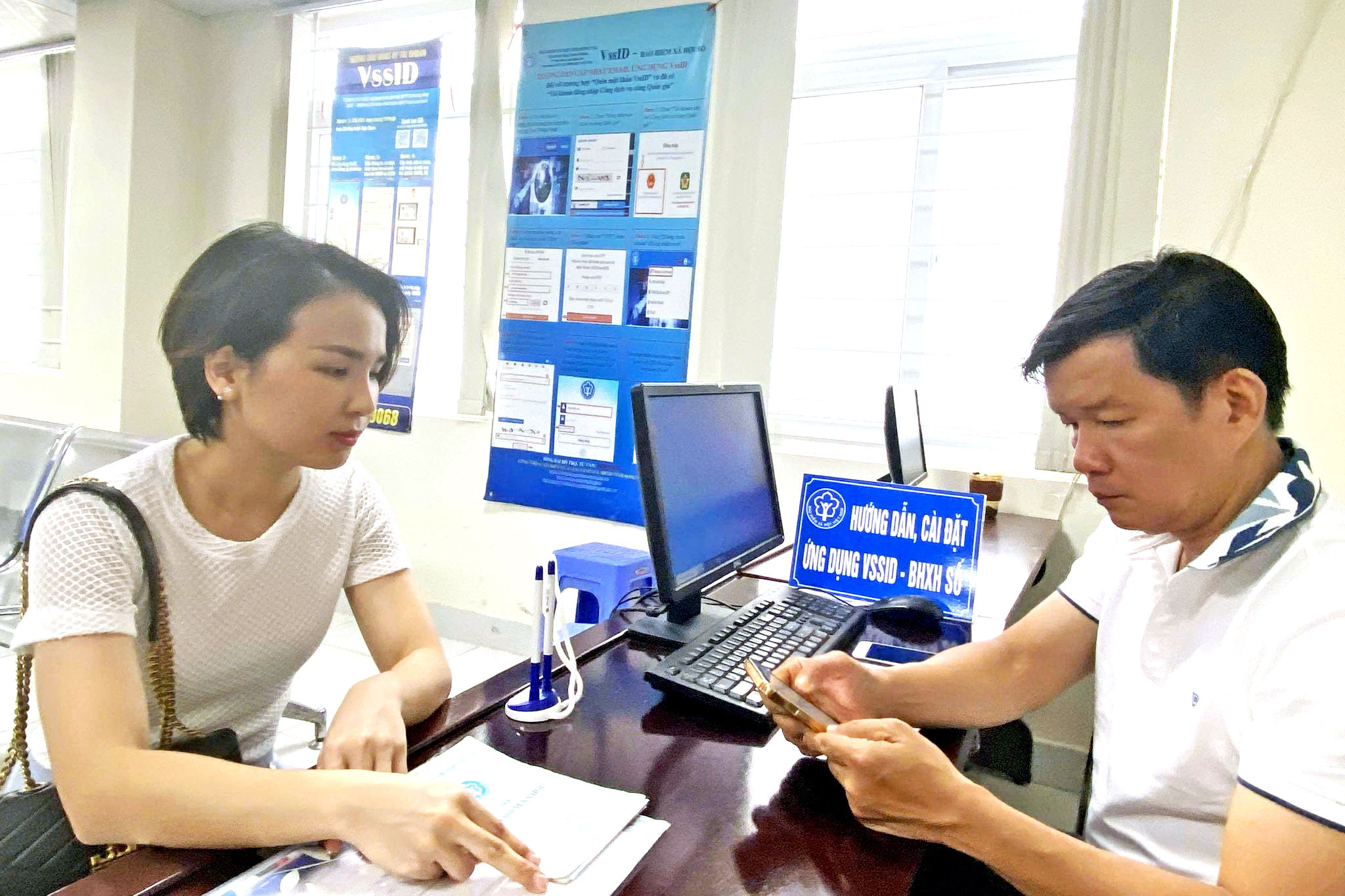 Cán bộ bảo hiểm xã hội thành phố Đồng Nai hướng dẫn người dân cài đặt ứng dụng VSSID - BHXH số