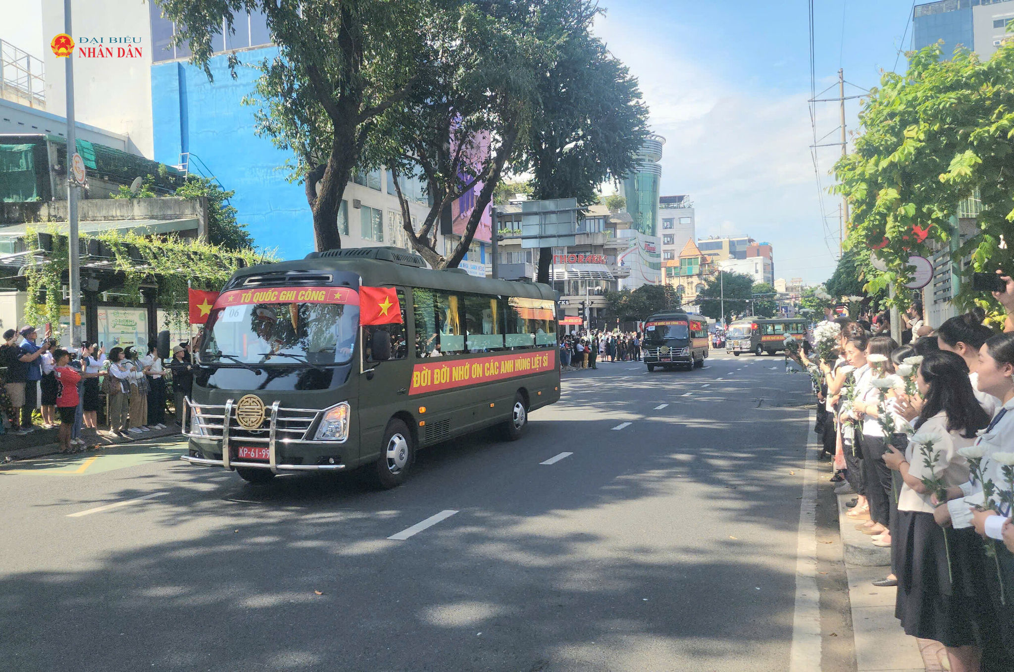 Người dân đứng trang nghiêm hai bên đường Điện Biên Phủ khi đoàn xe trở hài cốt các Anh hùng liệt sĩ đi qua. Ảnh Nguyễn Tuấn