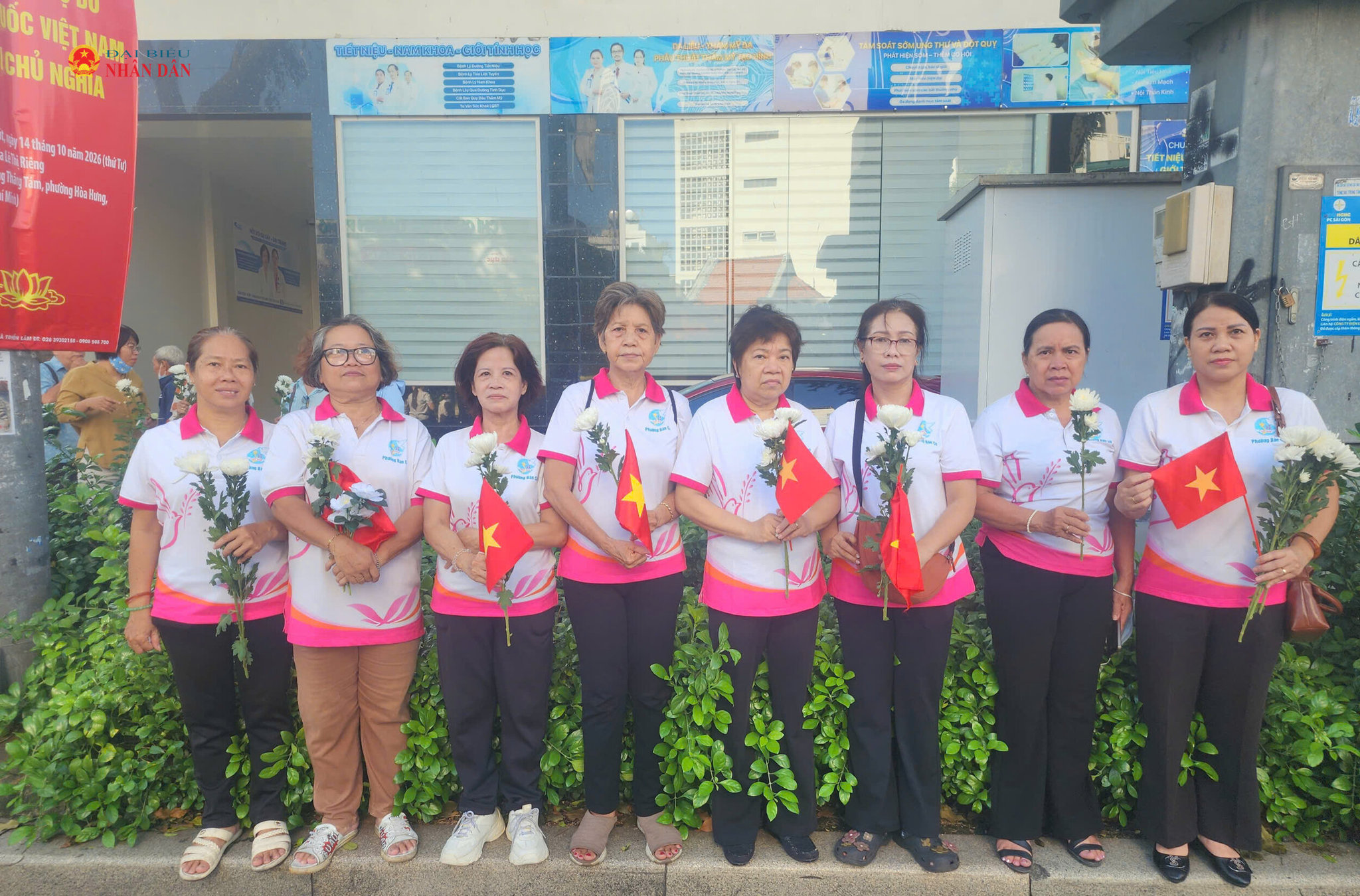 Hội Phụ nữ phường Bàn Cờ cầm hoa cúc trắng và cờ tổ quốc đừng bên đường Điện Biên Phủ tiễn đưa các Anh hùng liệt sĩ. Ảnh Nguyễn Tuấn