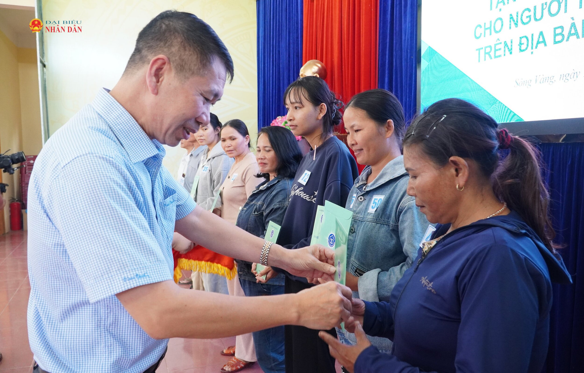 Giám đốc BHXH thành phố Đà Nẵng Nguyễn Trí Đại trao sổ BHXH cho các hộ nghèo của xã Sông Vàng.