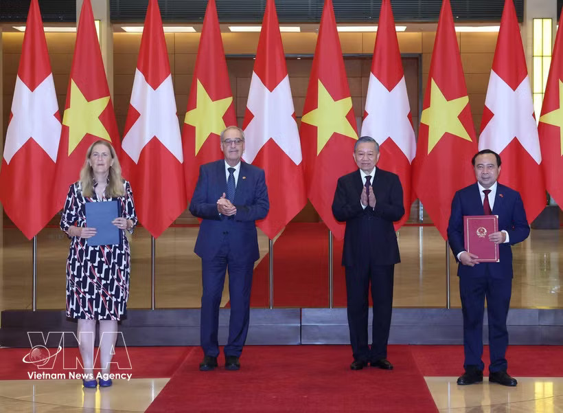 General Secretary of the Communist Party of Vietnam Central Committee and President To Lam (second from right) and Swiss President Guy Parmelin (second from left) witness the exchange of cooperation documents between ministries and agencies. (Photo: VNA)