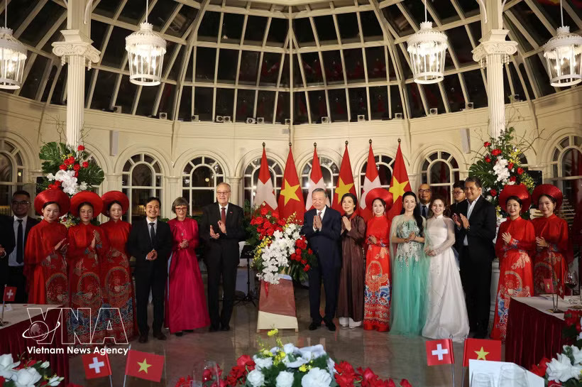 General Secretary of the Communist Party of Vietnam Central Committee and President To Lam (8th from left, first row) and his spouse Ngo Phuong Ly, and Swiss President Guy Parmelin and his spouse Caroline Parmelin present flowers to artists performing at the banquet. (Photo: VNA)
