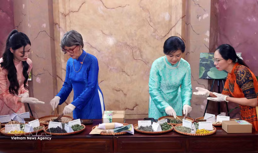 Madam Ngo Phuong Ly (second from right) and Madam Caroline Parmelin (second from left) make herbal pillows using traditional ingredients. (Photo: VNA)