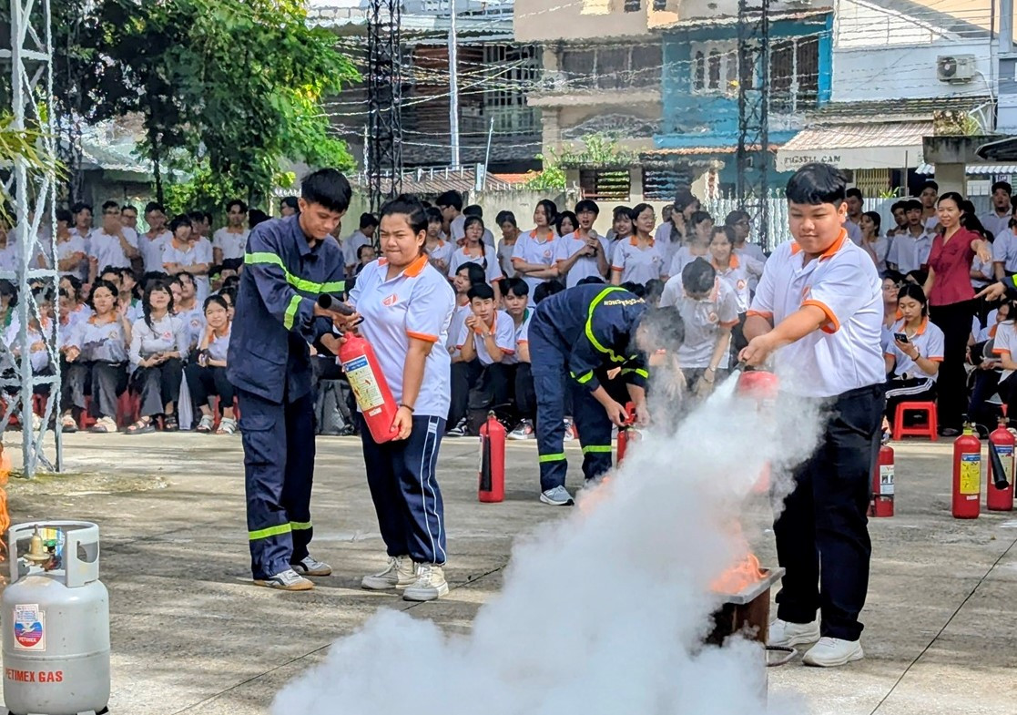 Các em học sinh trực tiếp được cán, bộ chiến sĩ PCCC hướng dẫn sử dụng bình chữa cháy dập lửa