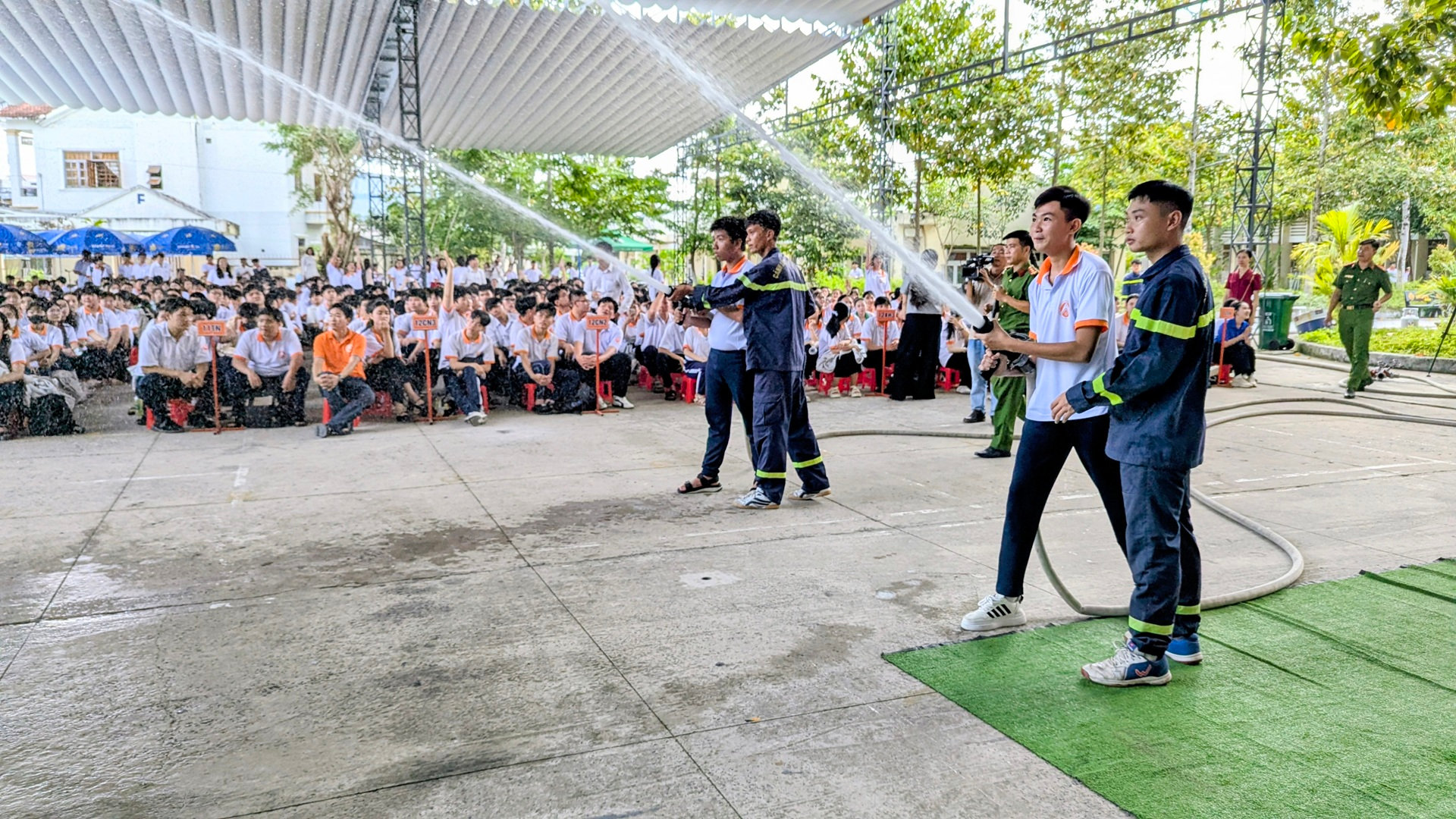 Các em học sinh lần đầu tiên cầm vòi nước, thực hành phun nước tiêu điểm
