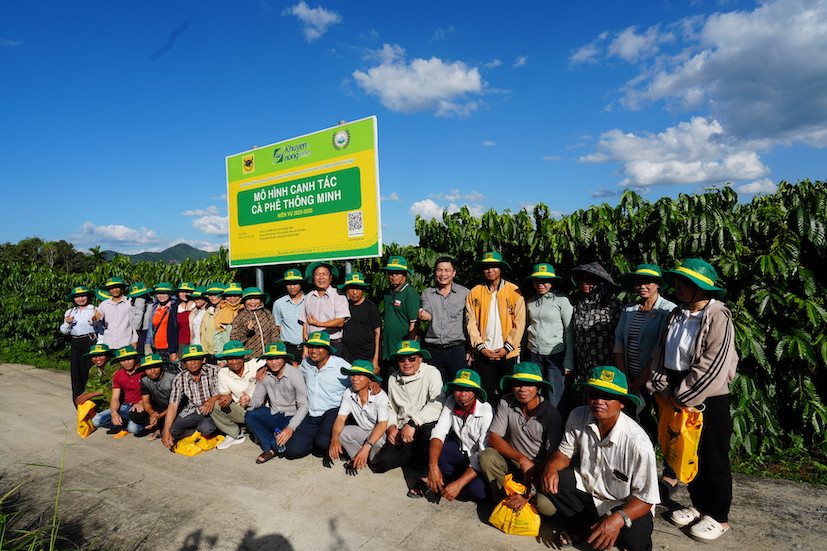 Đại biểu, nhà khoa học và nông dân chụp ảnh lưu niệm trước bảng mô hình Canh tác cà phê thông minh tại Đắk Hà