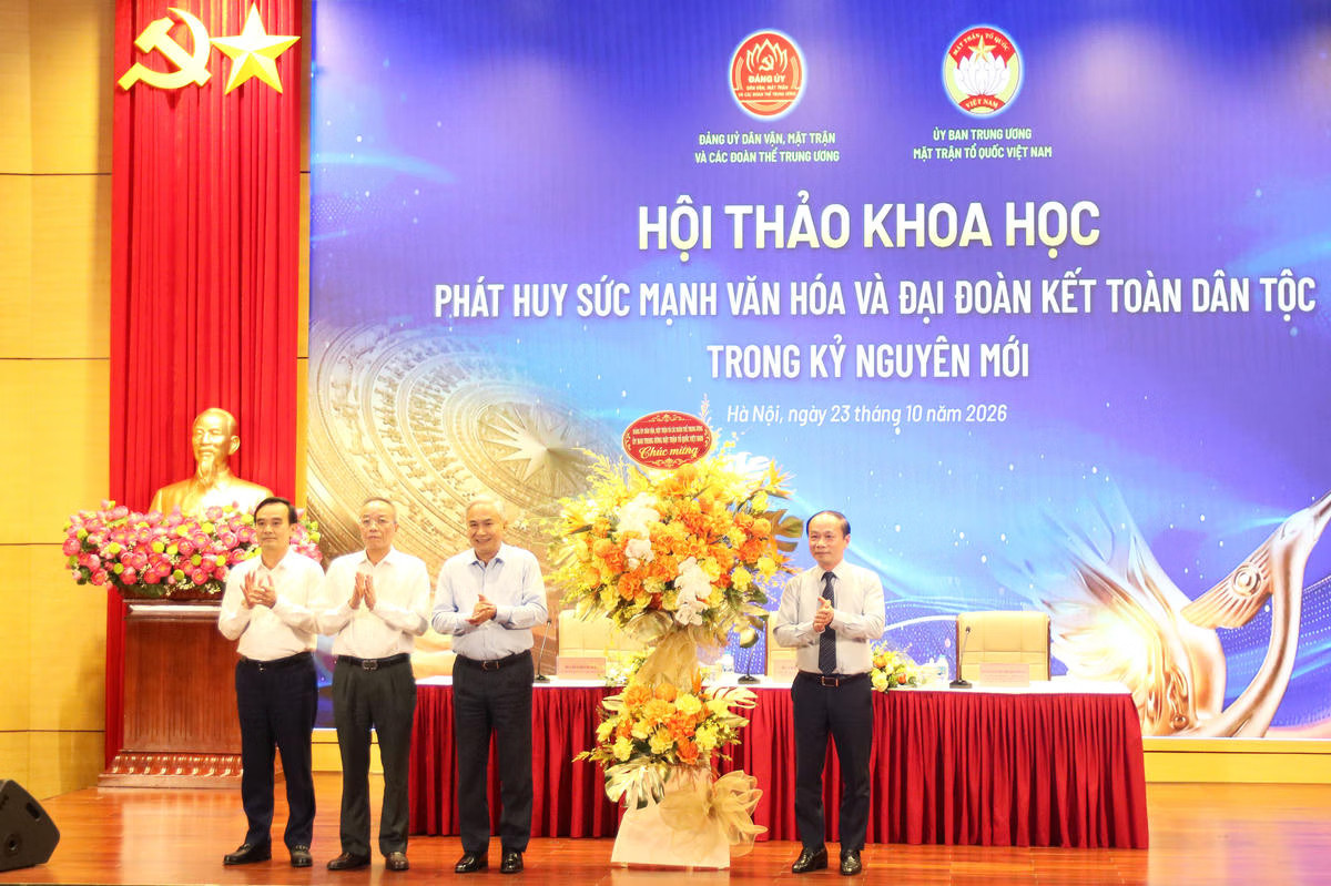 Phó Bí thư chuyên trách Đảng ủy Dân vận, Mặt trận và các đoàn thể Trung ương Phạm Tất Thắng tặng hoa chúc mừng Hội thảo