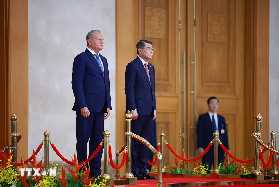 Thủ tướng Lê Minh Hưng và Thủ tướng Ba Lan Donald Tusk thực hiện nghi lễ chào cờ