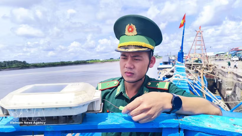 Maj. Phan Minh Vuong, head of the Ganh Hao Border Guard Control Station, inspects the VMS system on a fishing boat (Photo: VNA)