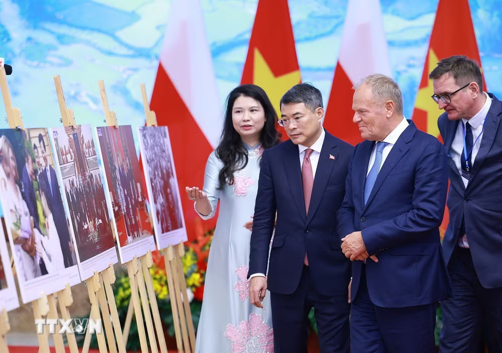 Thủ tướng Lê Minh Hưng và Thủ tướng Cộng hòa Ba Lan Donald Tusk tham quan trưng bày ảnh về quan hệ hợp tác giữa hai nước do Thông tấn xã Việt Nam thực hiện. (