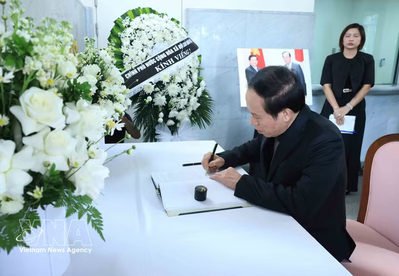 Deputy Prime Minister Le Tien Chau writes in the condolence book. (Photo: VNA)