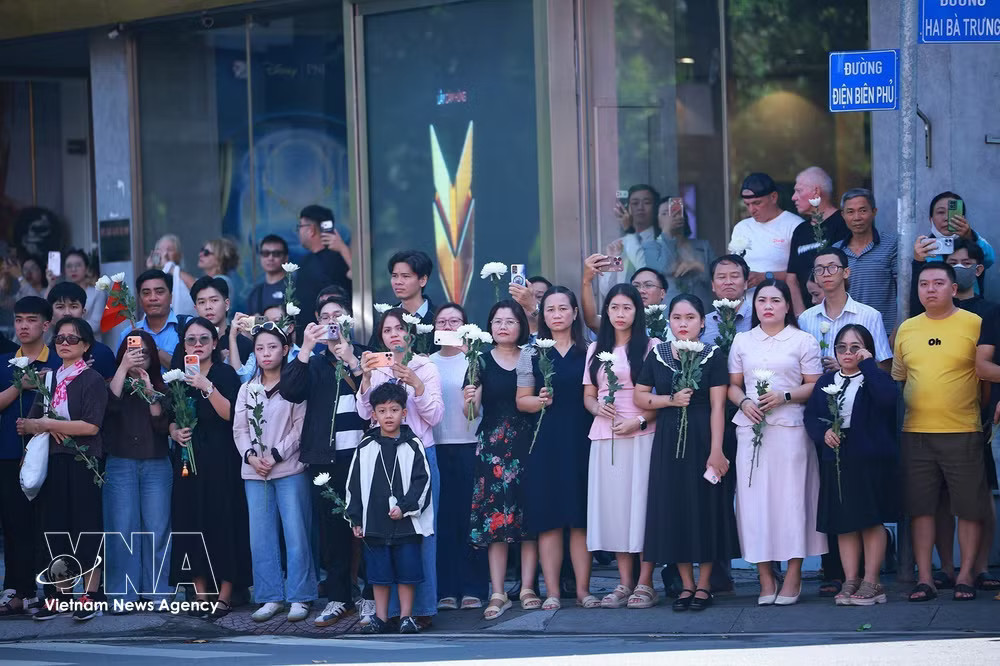 Along the 26-kilometre route through 11 wards, tens of thousands of residents line the streets with white flowers to pay their respects as the procession passes. (Photo: VNA) vnanet-h.jpg