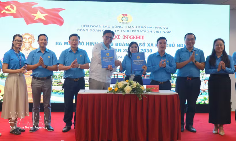 A leader of Pegatron Vietnam Co., Ltd. sign an agreement with the firm's trade union. (Photo: VNA)
