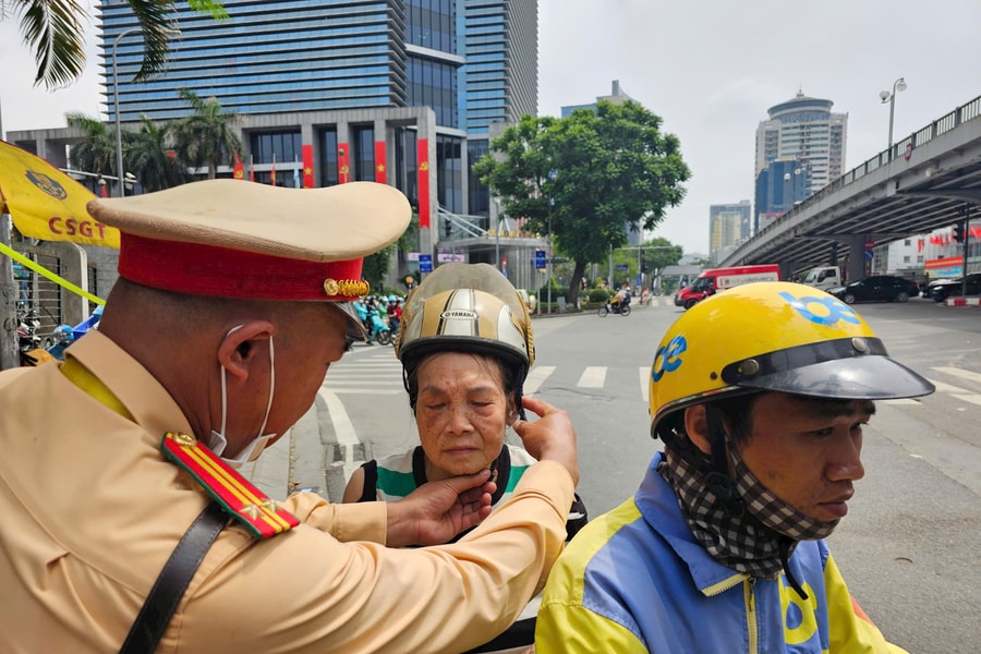 Cảnh sát giao thông hỗ trợ cụ bà mệt mỏi giữa trưa nắng trở về nhà an toàn